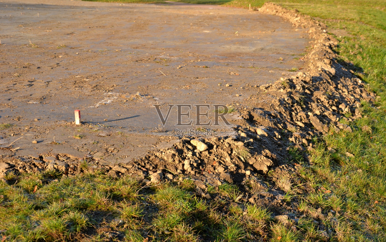 用振动压路机和尖板进行平整和压实土壤的施工准备工作。疏浚和覆盖草地生长的地方平整、栽植、地体、树干、推照片摄影图片