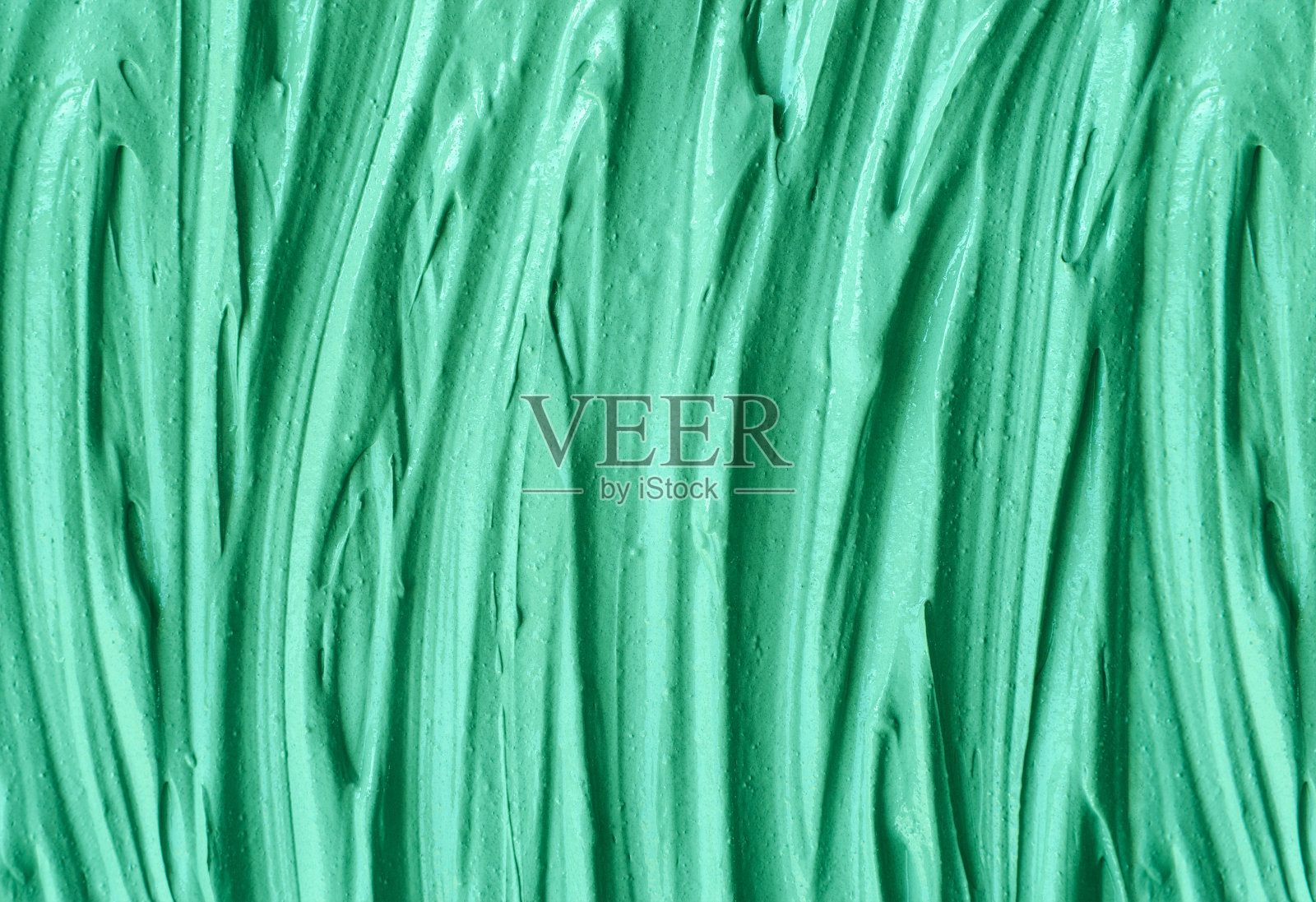 绿色化妆粘土(海带面膜、面霜、螺旋藻体贴)质地近距离,选择性聚焦。抽象的背景与画笔笔触。照片摄影图片