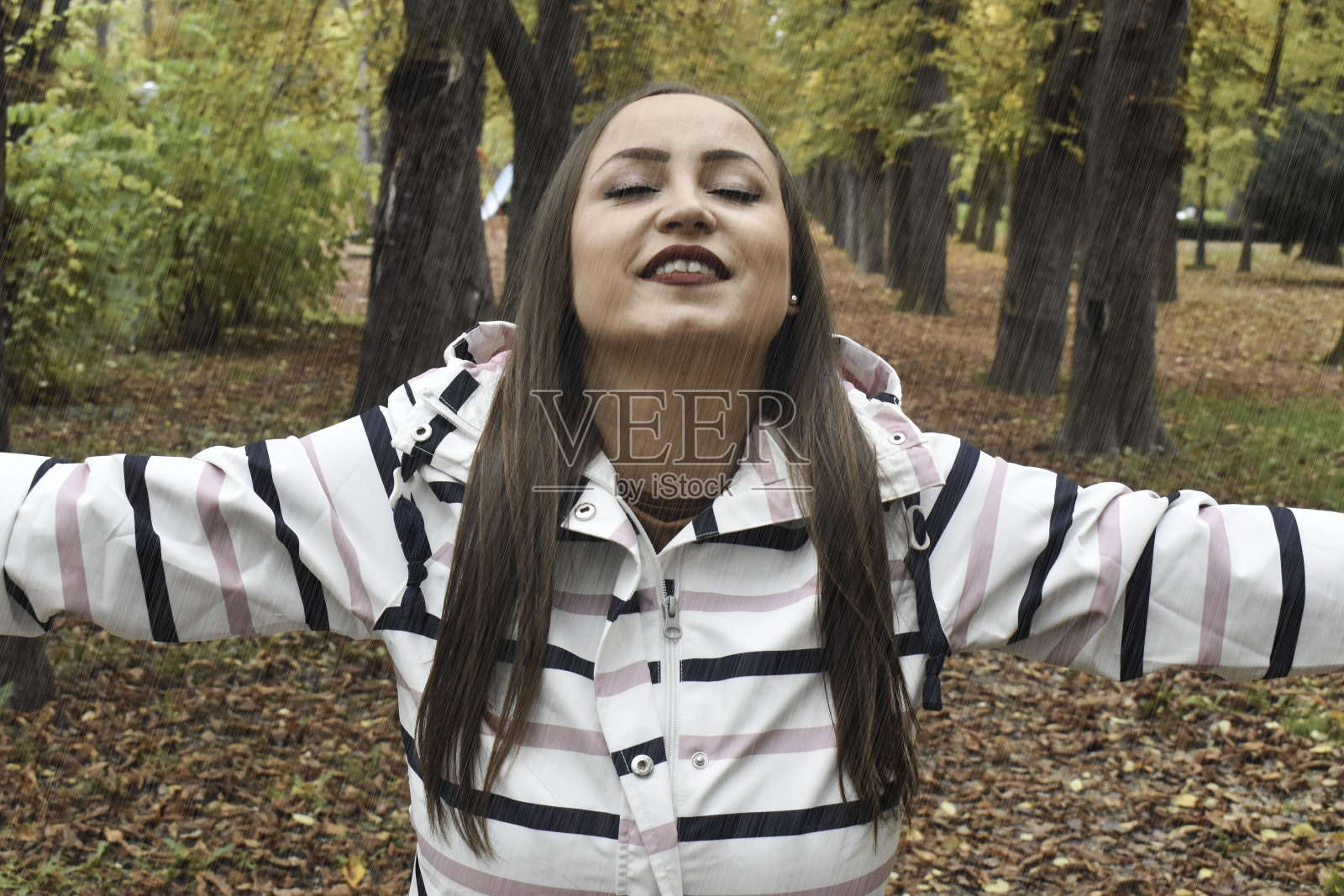 女人在户外的公园里,下雨照片摄影图片