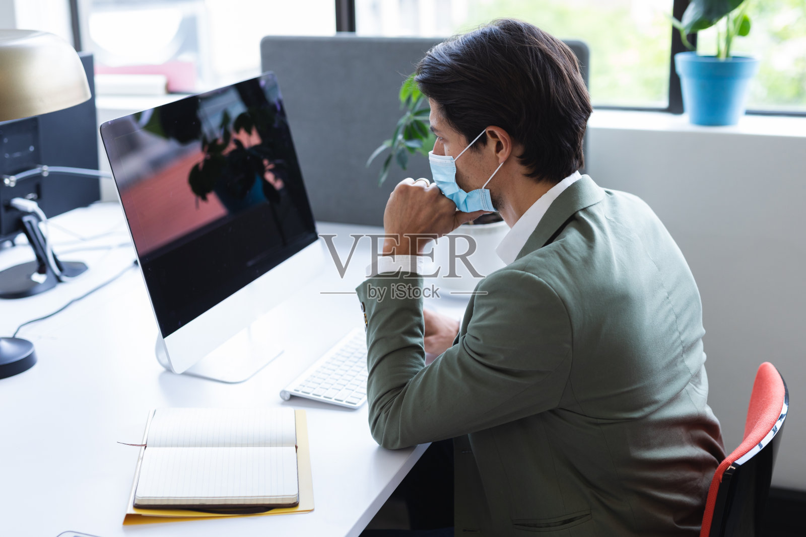 办公室里戴着面具的白人男子照片摄影图片