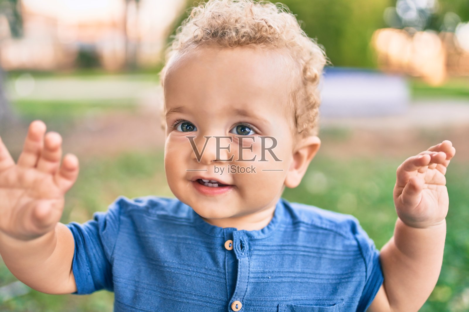 可爱和快乐的小男孩在一个阳光明媚的日子在公园玩。漂亮的金发男孩在户外玩耍照片摄影图片