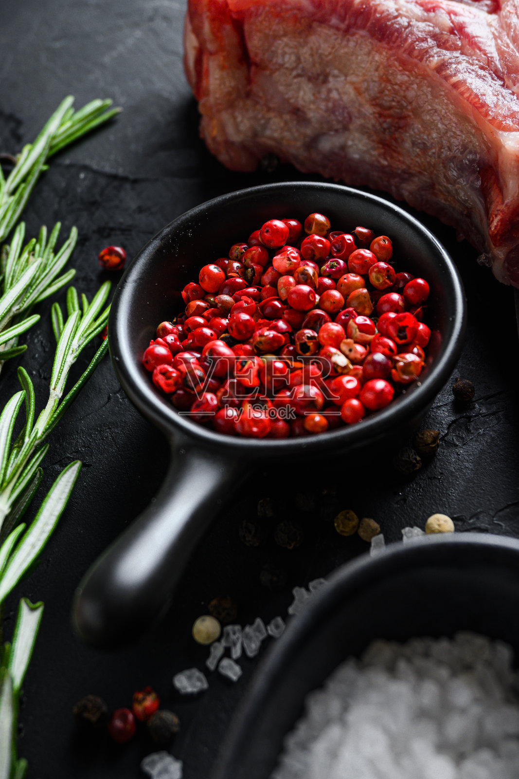 玫瑰、胡椒和迷迭香药草近距离与香料和生肉近侧视图选择焦点垂直。照片摄影图片