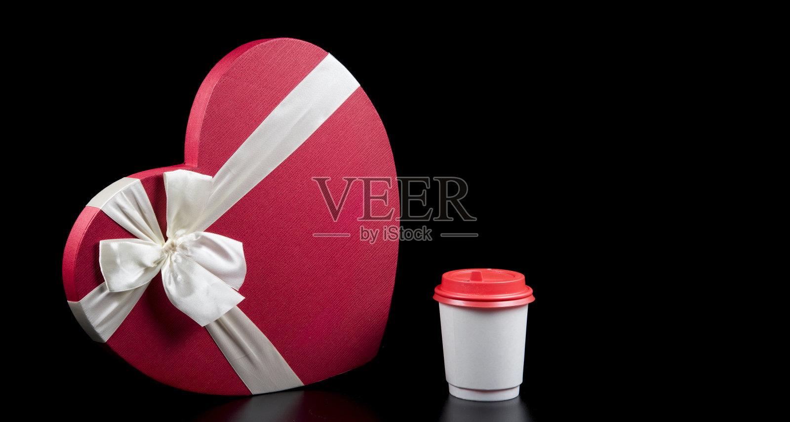 红色的心形礼盒和白色的纸咖啡杯孤立在黑色的背景。情人节横幅。爱和咖啡的概念。Copyspace文本照片摄影图片