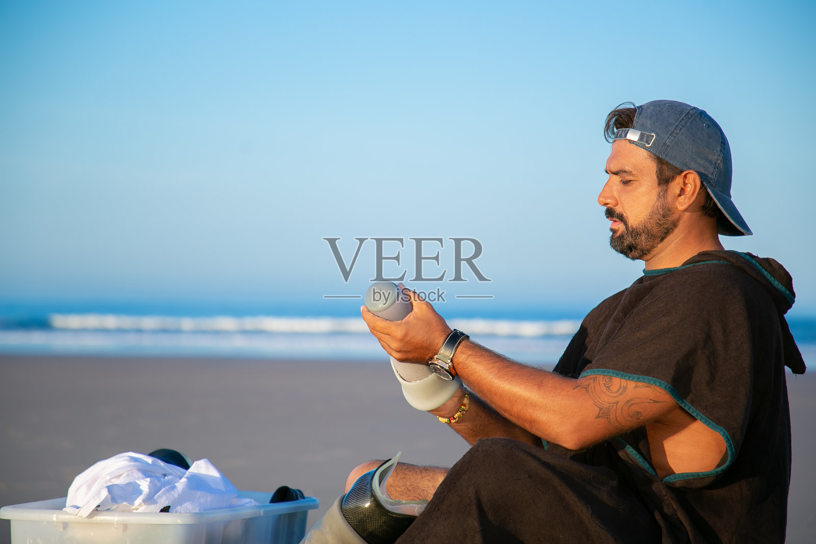 坐在海滩上的专注的年轻人照片摄影图片