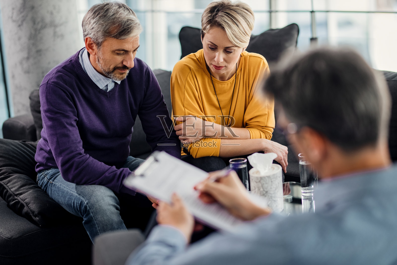 心烦意乱的夫妇正在接受婚姻咨询师的治疗。照片摄影图片