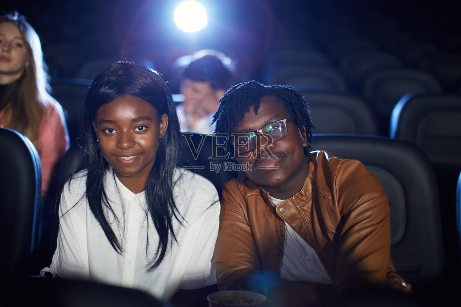 非洲夫妇在电影院摆姿势。照片摄影图片
