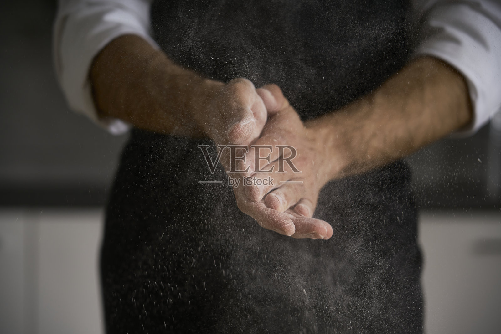 强壮的男人用双手揉面团,他们可以用面团做面包、意大利面、蛋糕或披萨。照片摄影图片