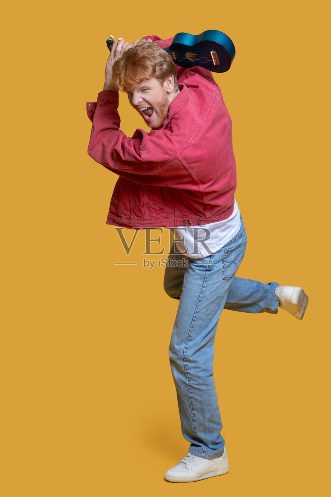 穿着红夹克的男人带着四弦琴感觉兴奋照片摄影图片