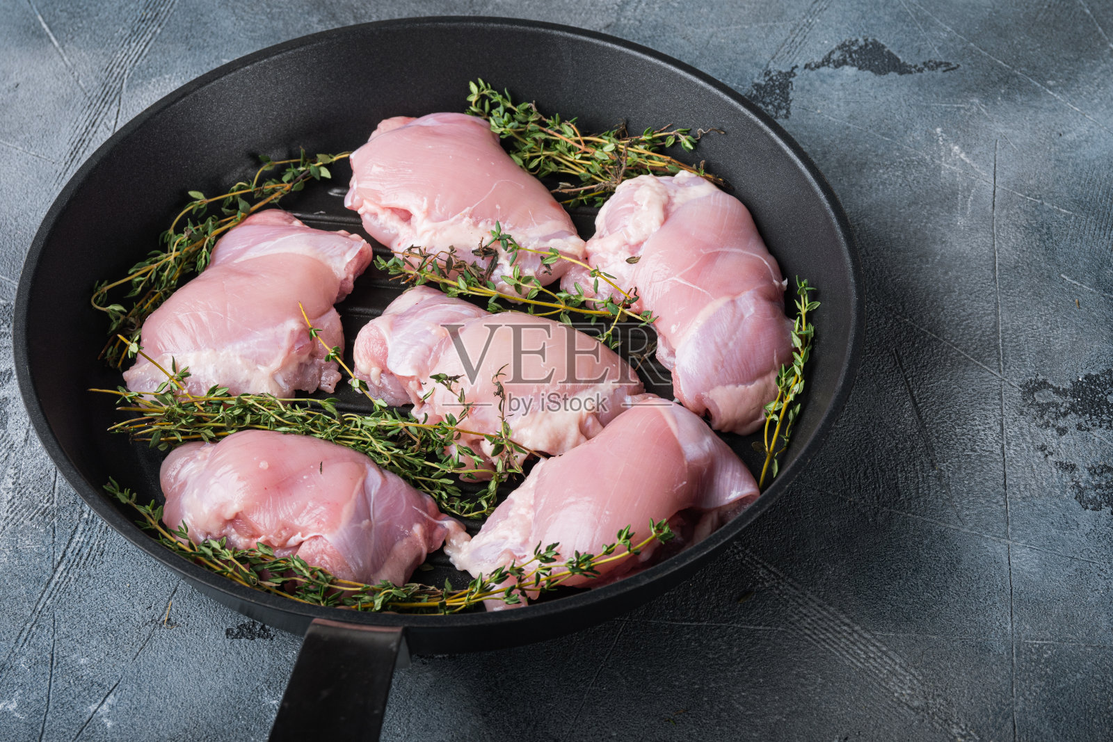 在灰色背景的烤盘上加时间的鸡腿照片摄影图片