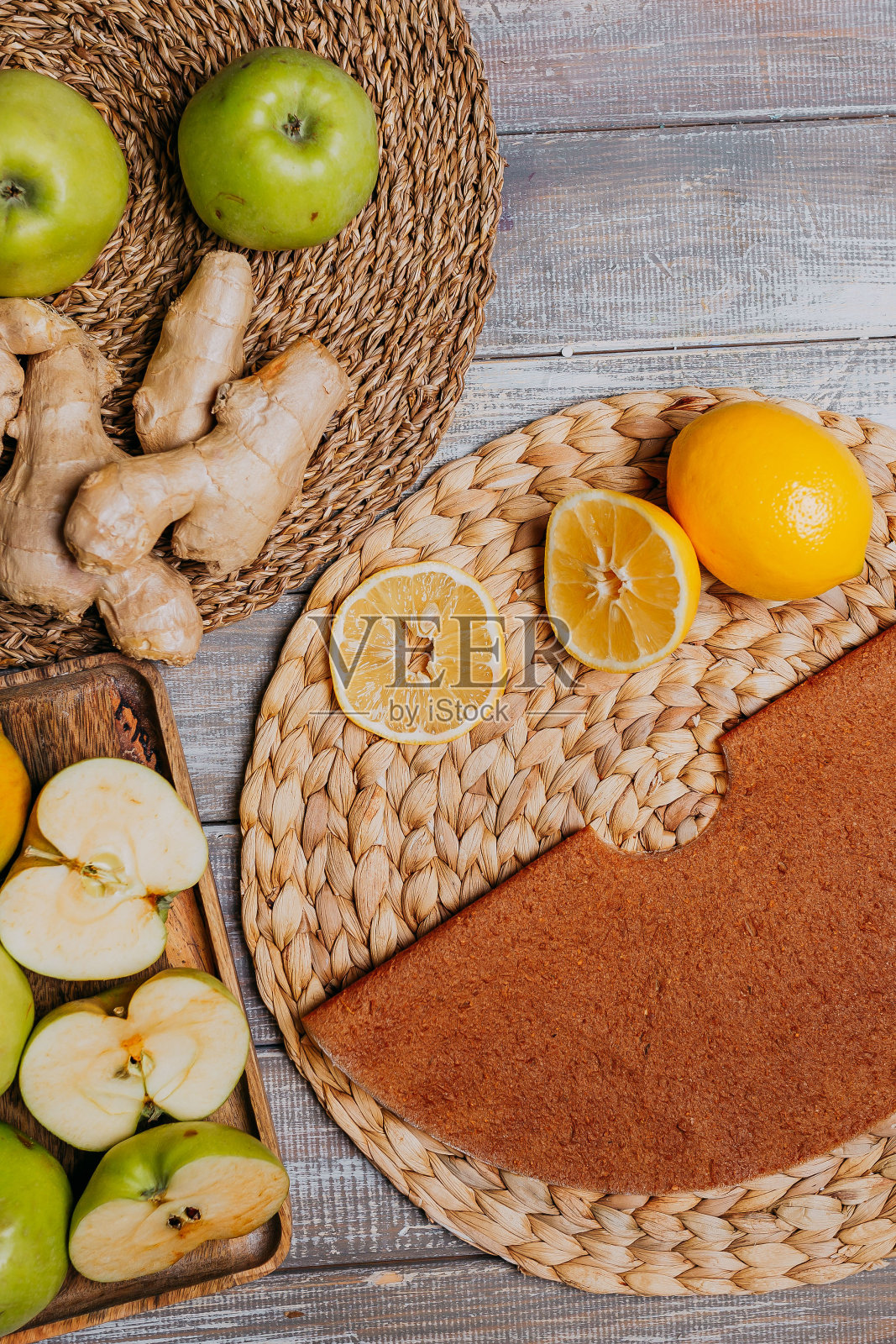 柠檬和生姜水果皮革和新鲜的水果在木桌上。圆的水果皮。健康食品。苹果,香蕉,酸橙,生姜俯视图。照片摄影图片