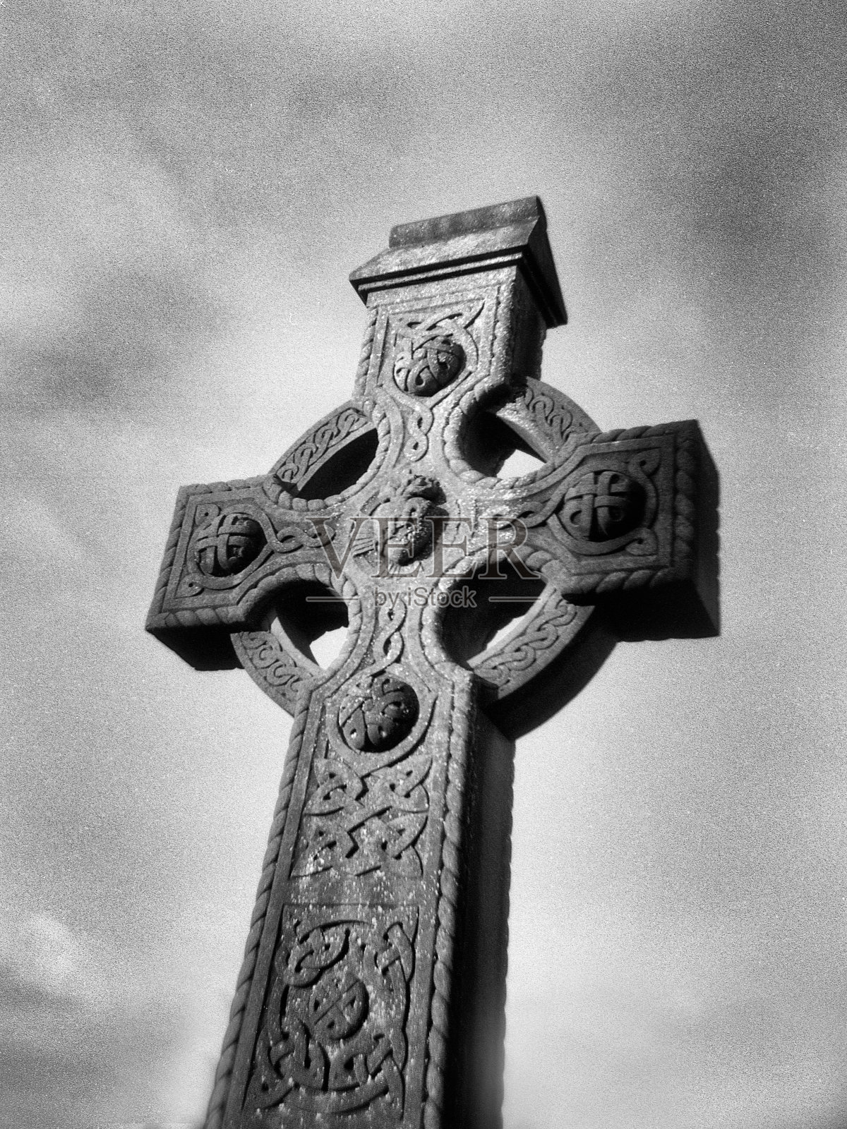 背景中的爱尔兰非常古老的神圣十字架,天空多云照片摄影图片