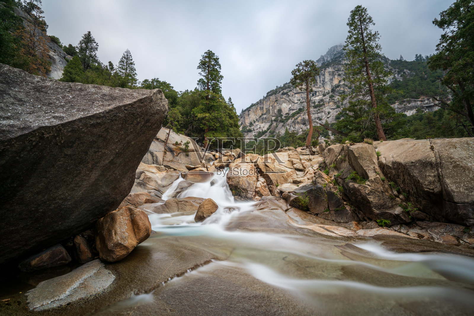 在一个多云的日子里,国王河从山上流下来,在加利福尼亚国王峡谷国家公园的薄雾瀑布小径上,可以看到山脉照片摄影图片