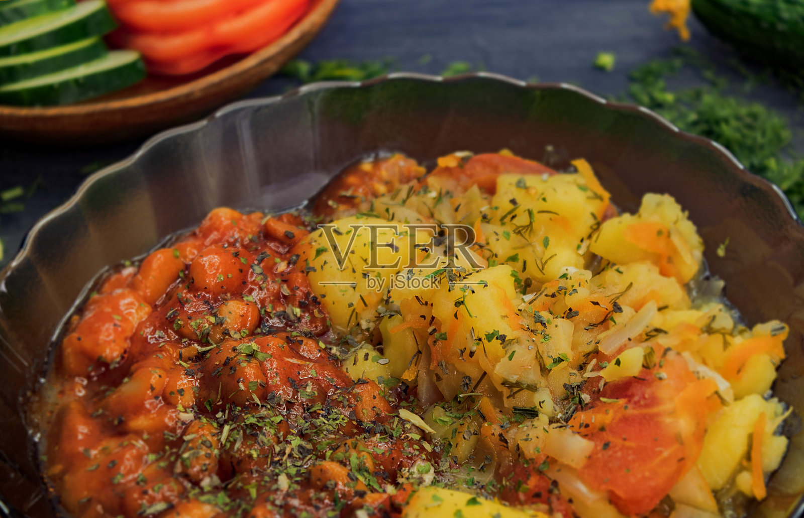 酱汁豆、土豆和胡萝卜放在一个棕色透明深盘里照片摄影图片