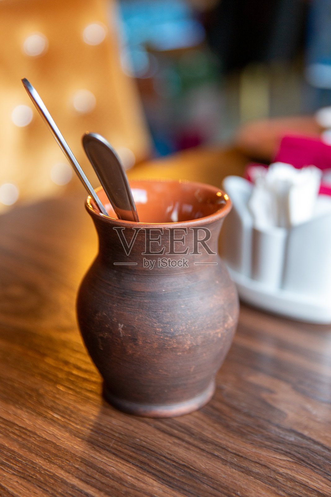 刀叉放在桌子上的陶罐里照片摄影图片