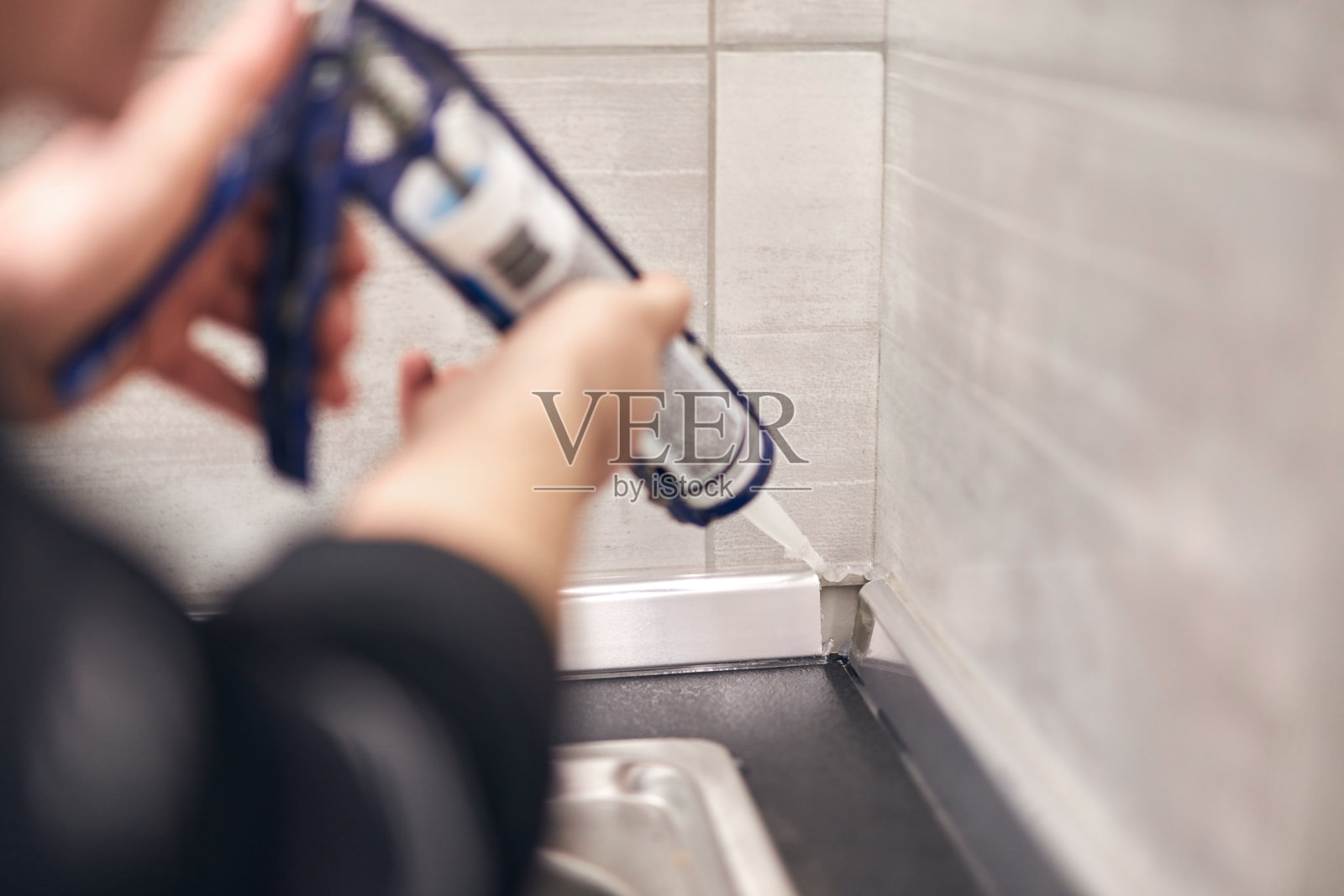 杂务工用硅酮密封胶粘合固定家居用品。照片摄影图片