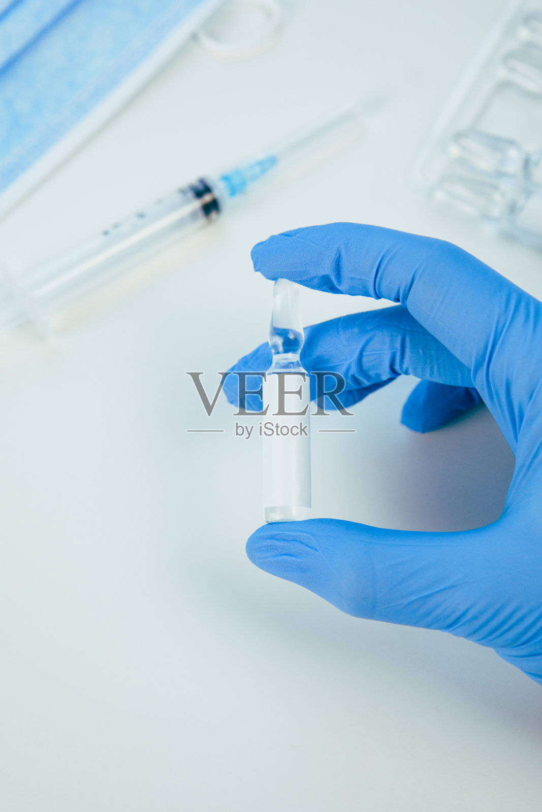 将装有疫苗的安瓿的医用手套交于手照片摄影图片
