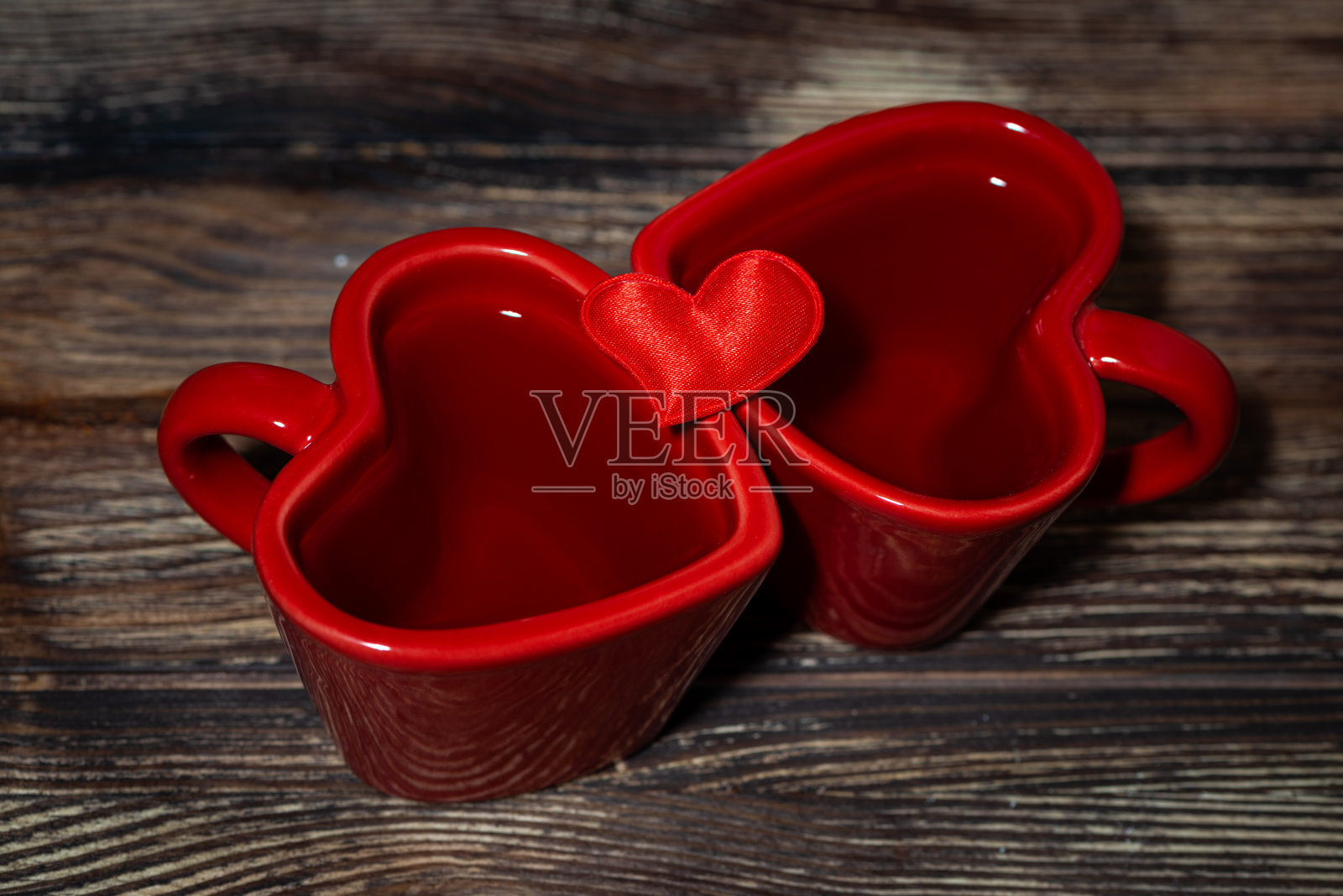两杯红色的心形茶在一个木制的背景,特写照片摄影图片