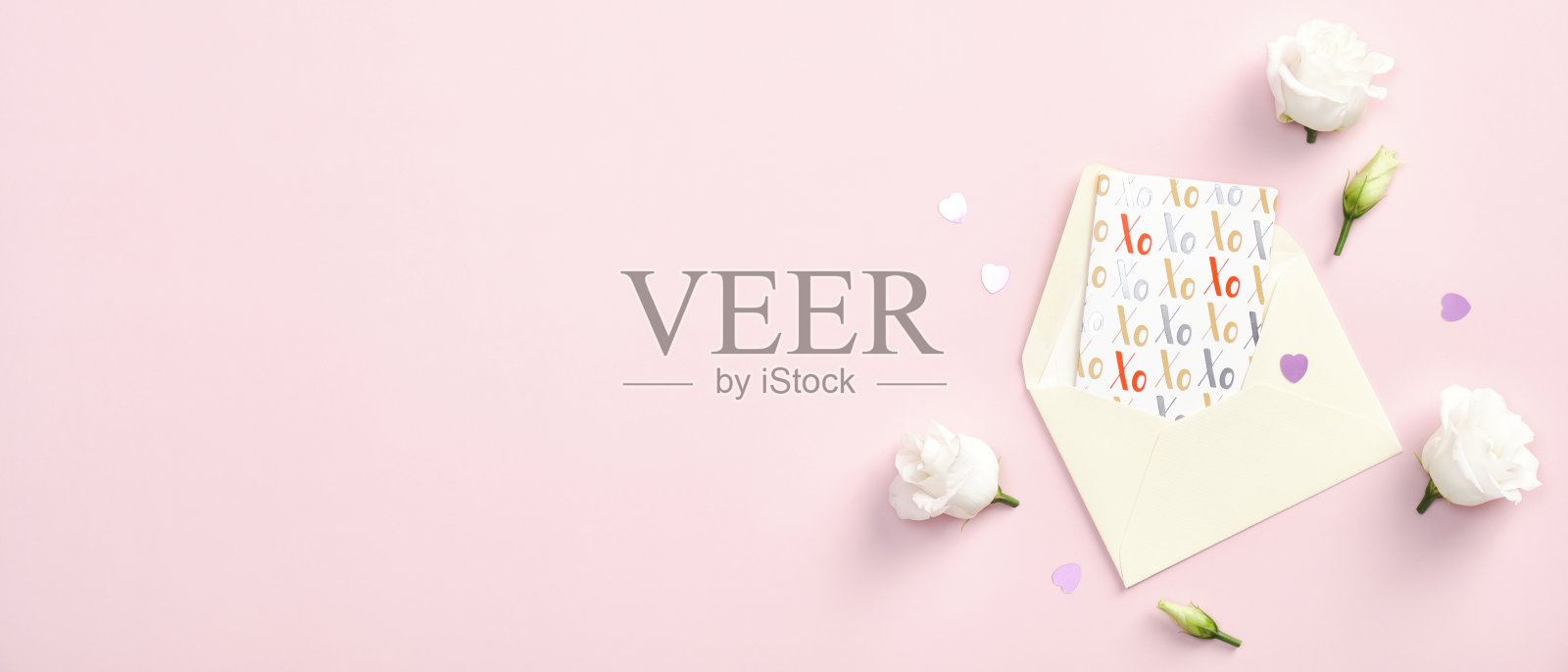 情人节横幅模板快乐。平铺纸信封,贺卡和玫瑰花在粉红色的背景。顶部视图与复制空间。照片摄影图片