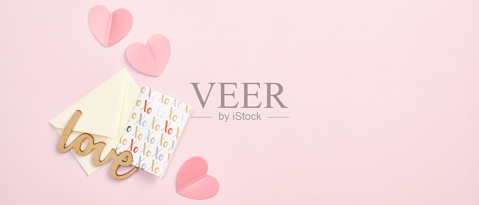 情人节横幅设计。浪漫的平铺构图,以信封、纸声和贺卡为粉色背景。顶部视图与复制空间。照片摄影图片