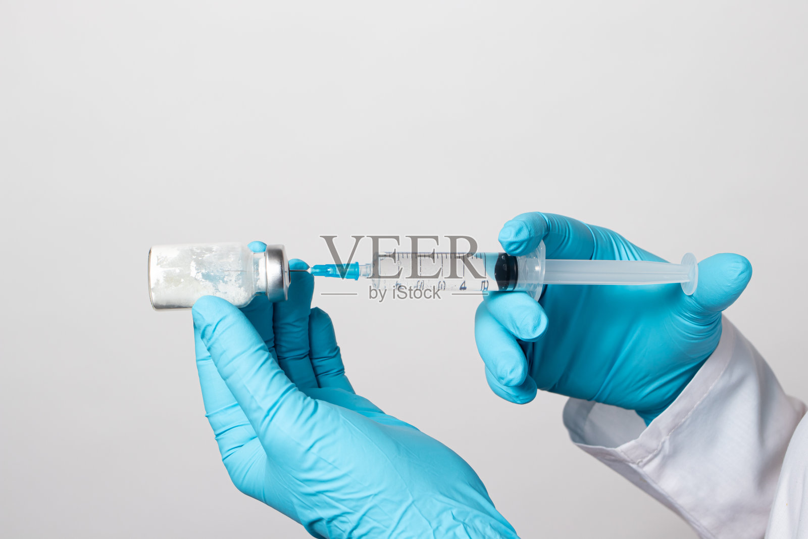 护士戴着手套的手用生理盐水稀释抗生素。特写照片。一步一步的指令,第二步照片摄影图片