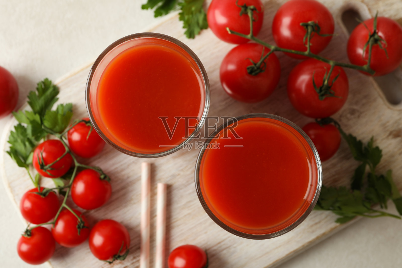 带有番茄汁和西红柿的板在白色纹理的背景上照片摄影图片