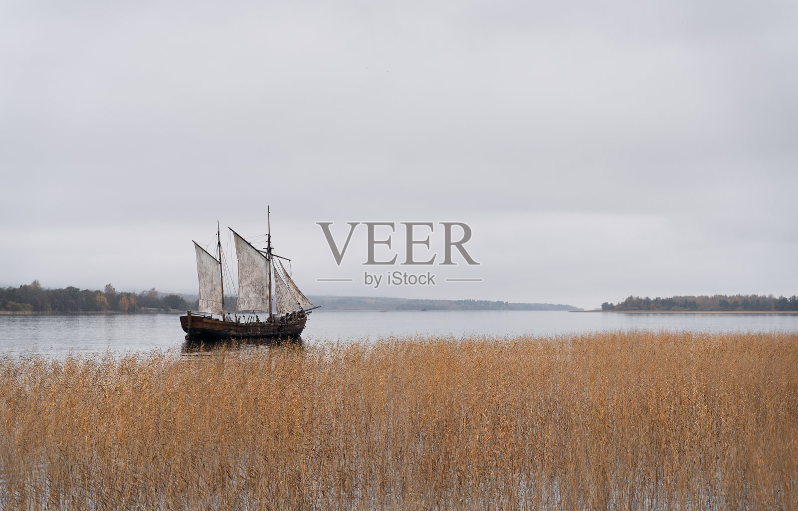 复古风格的木制旧船,所有的帆设置在雾蒙蒙的湖。照片摄影图片