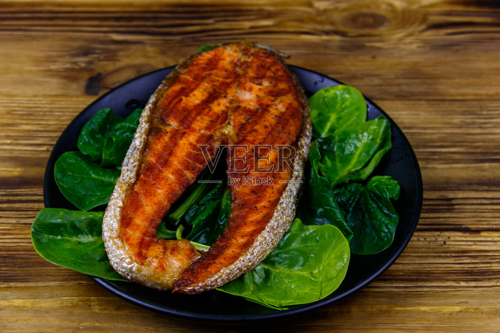 木桌上的菠菜烤鲑鱼排照片摄影图片