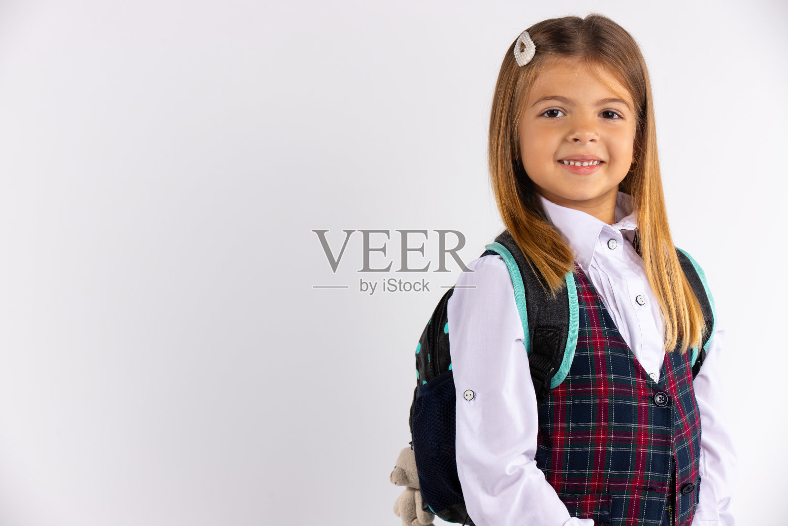 近距离的肖像微笑的白人女学生制服与金色长发看着镜头。孤立在白色背景与空白的边空间照片摄影图片