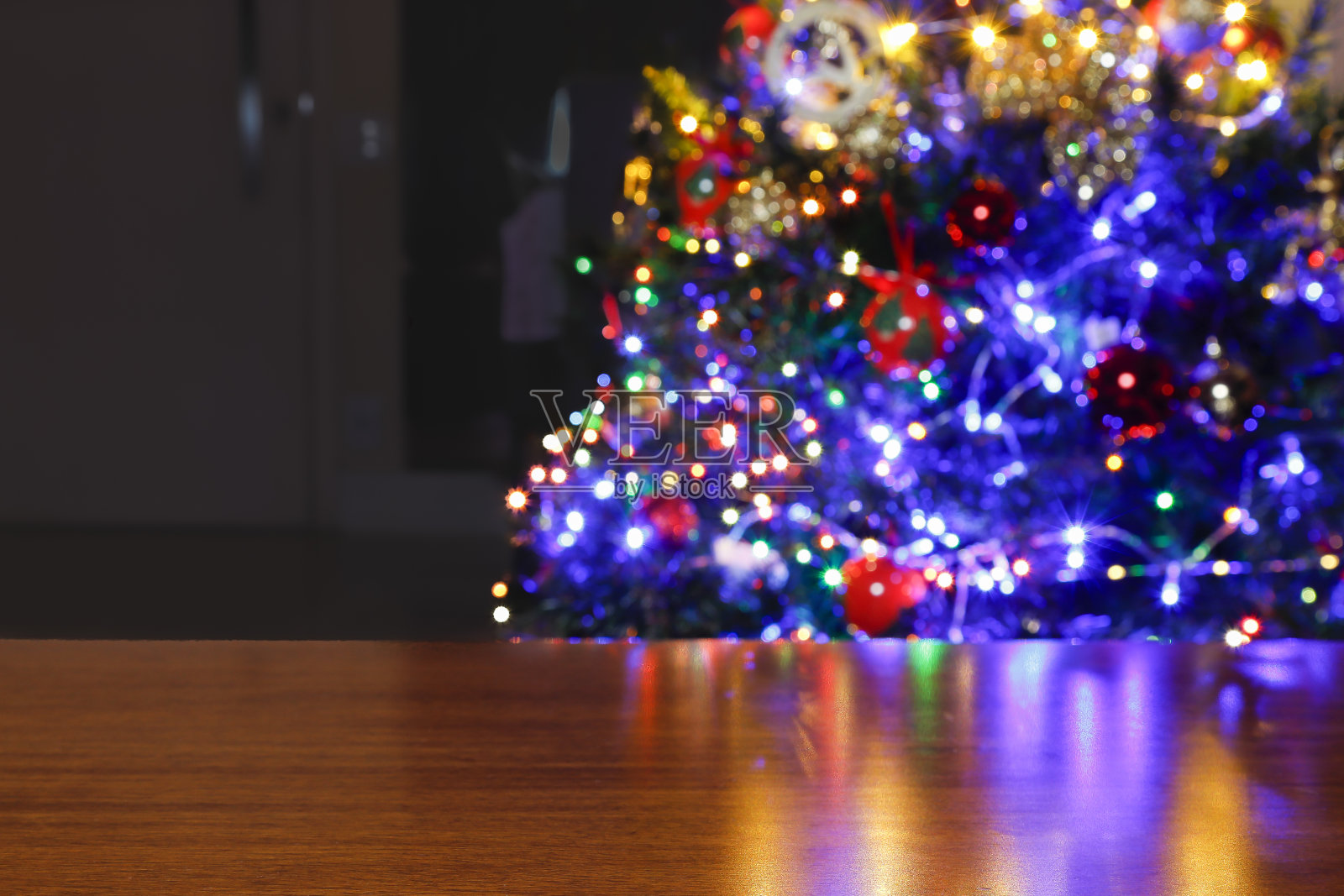 有圣诞树背景的木桌。照片摄影图片