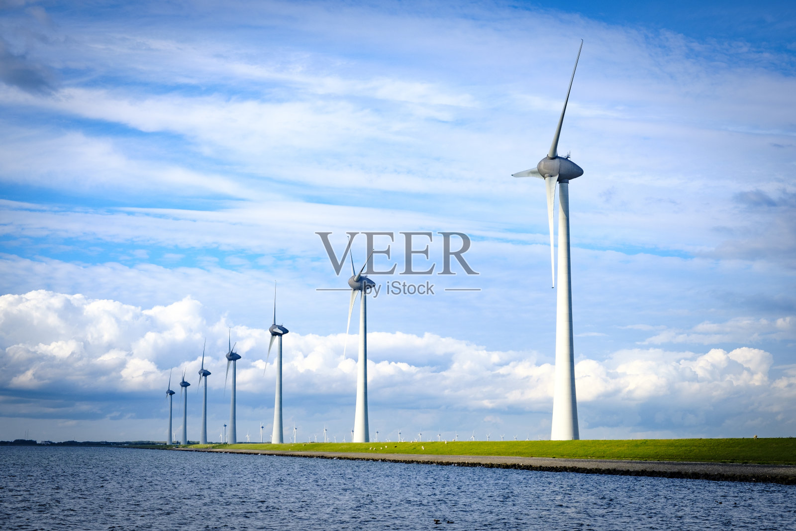 在一个有风的日子里,一排风力涡轮机在一个风公园里,背景是云照片摄影图片