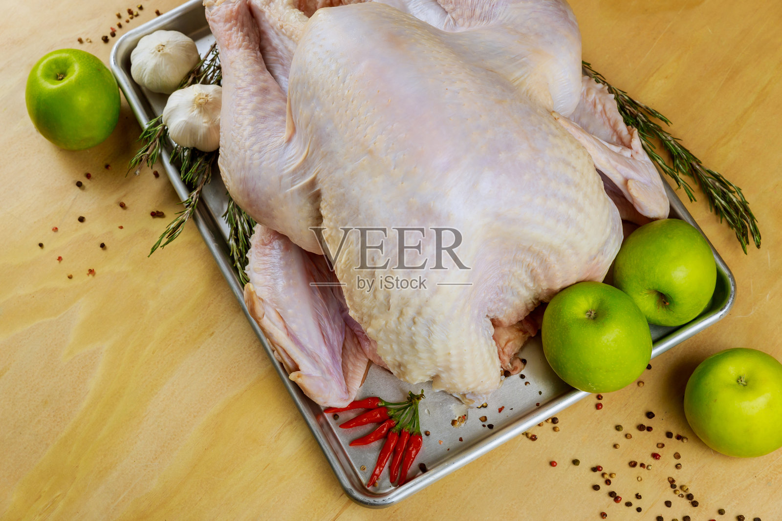 生火鸡放在烤盘里准备烹调。照片摄影图片