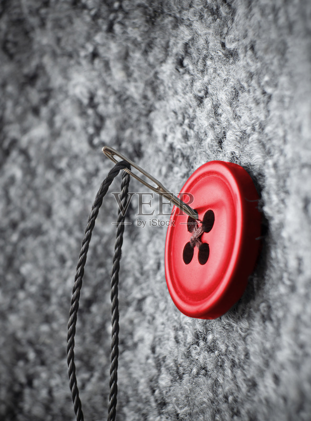 在厚外套上扣上钮扣,织物和针线照片摄影图片