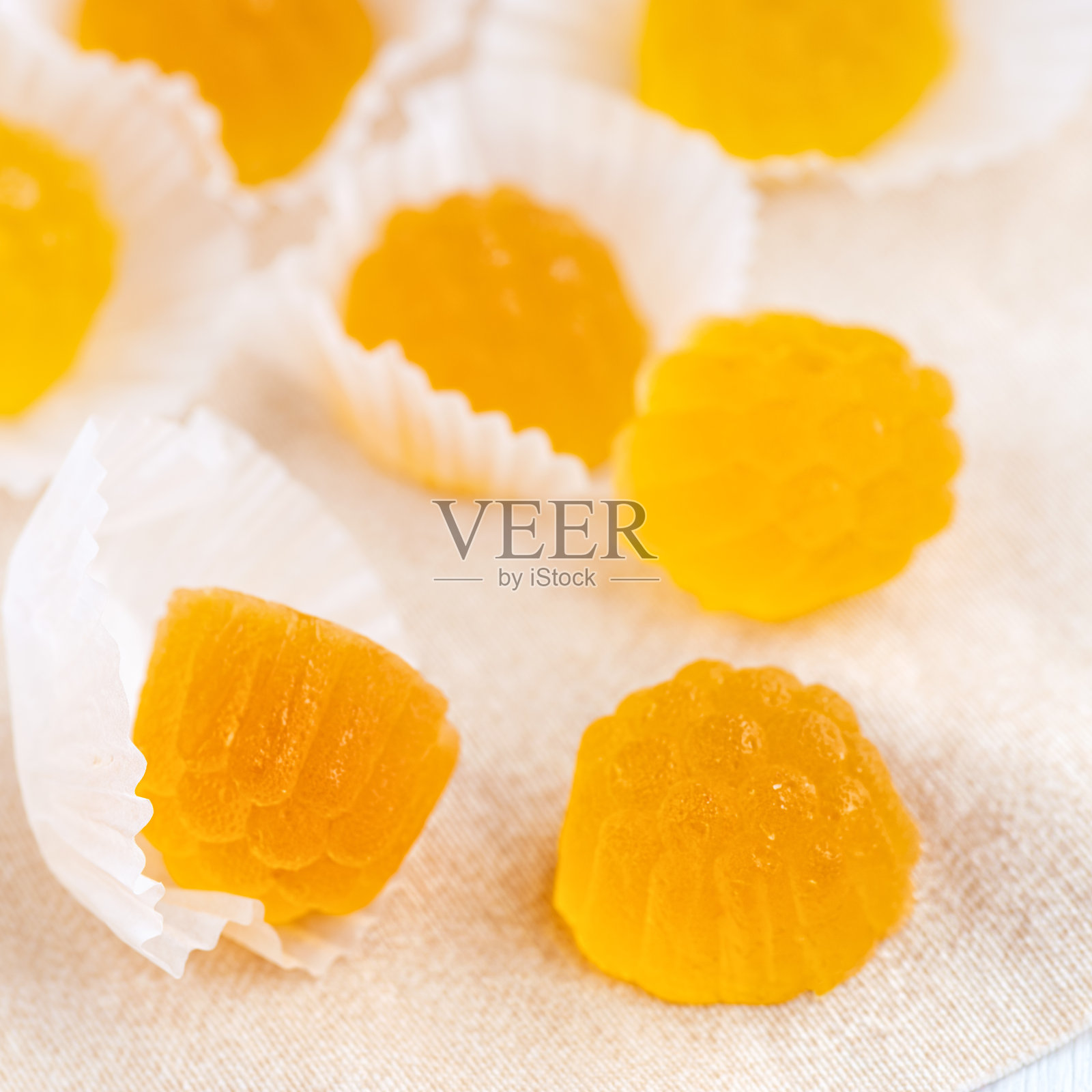 果冻形状的工艺橘子酱与橙汁。甜蜜的果冻糖黄色和橙色在明亮的桌子上。照片摄影图片