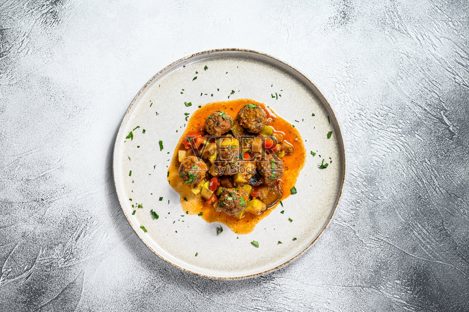 美味的蕃茄酱牛肉丸子,盛在旧的金属锅里。灰色的背景。俯视图照片摄影图片