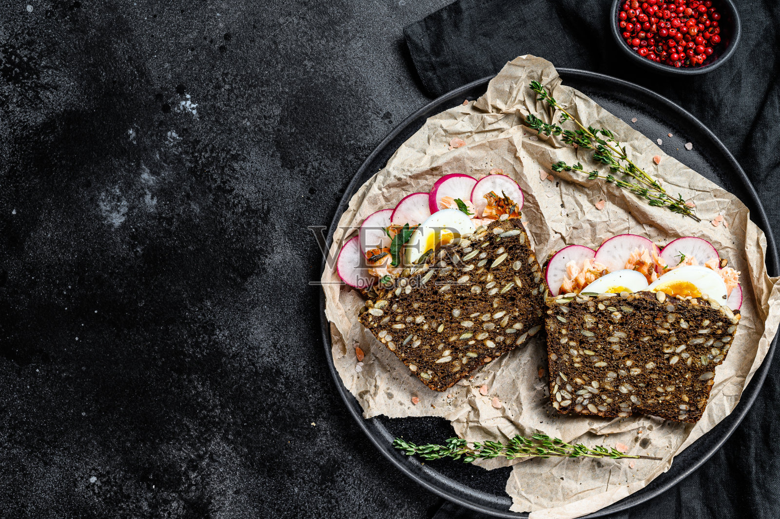 三明治配热烟熏鲑鱼和谷物面包。鳟鱼。黑色背景,俯视图,文本空间照片摄影图片