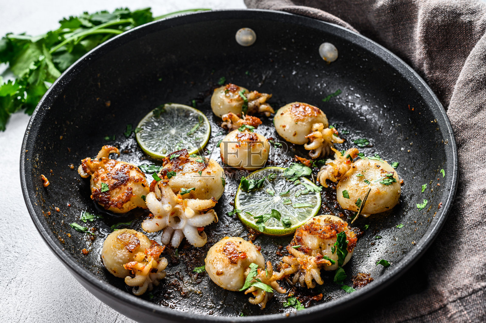 烤墨鱼与酸橙和香料在平底锅。灰色的背景。俯视图照片摄影图片