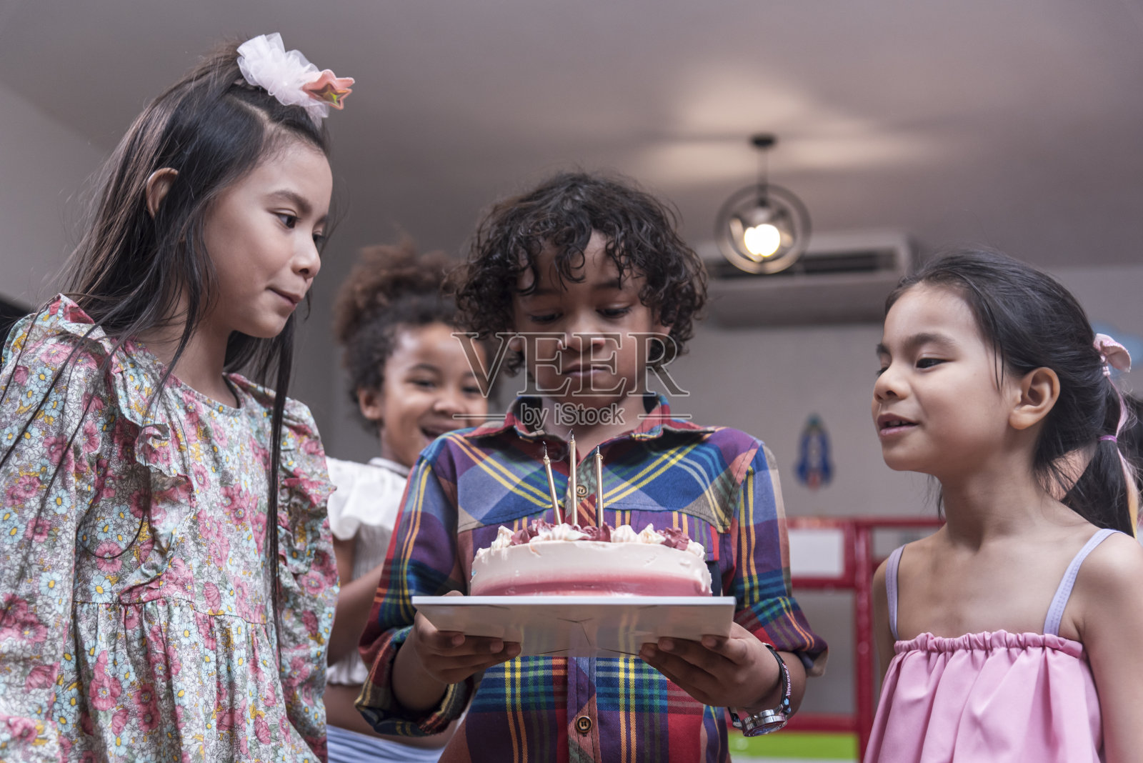 一群快乐和享受的孩子有乐趣庆祝她的生日与跨国朋友孩子的生日庆祝会。照片摄影图片