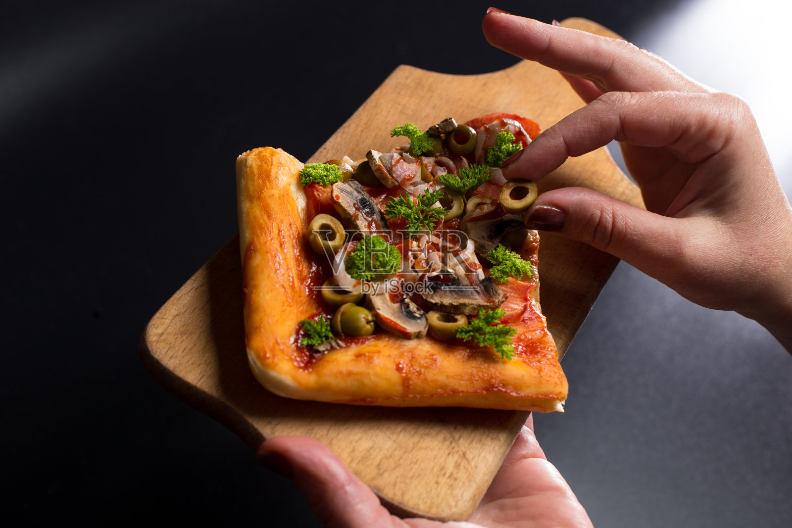 女人的手拿着一片披萨照片摄影图片