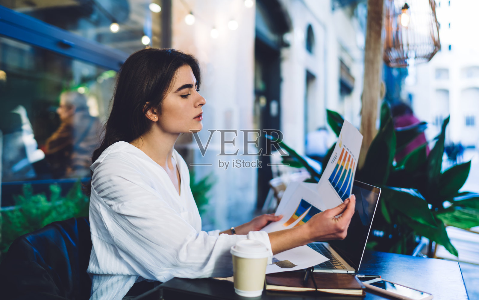 侧面的智能女性专业检查有利可图的市场分析在平台远程工作,高加索自由职业者分析信息图表和收入策略照片摄影图片