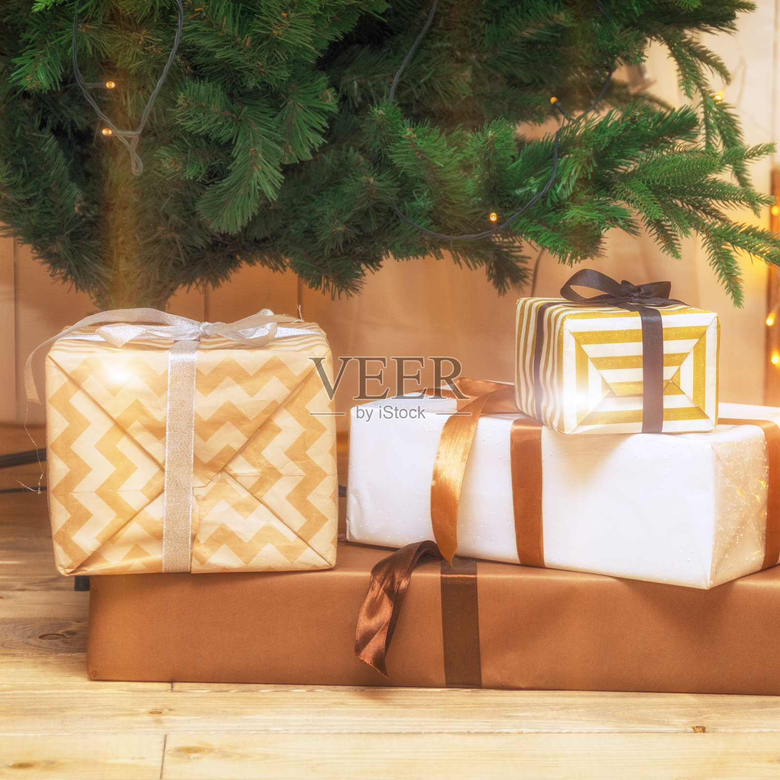 圣诞礼物装在节日盒子里放在圣诞树下的地板上照片摄影图片