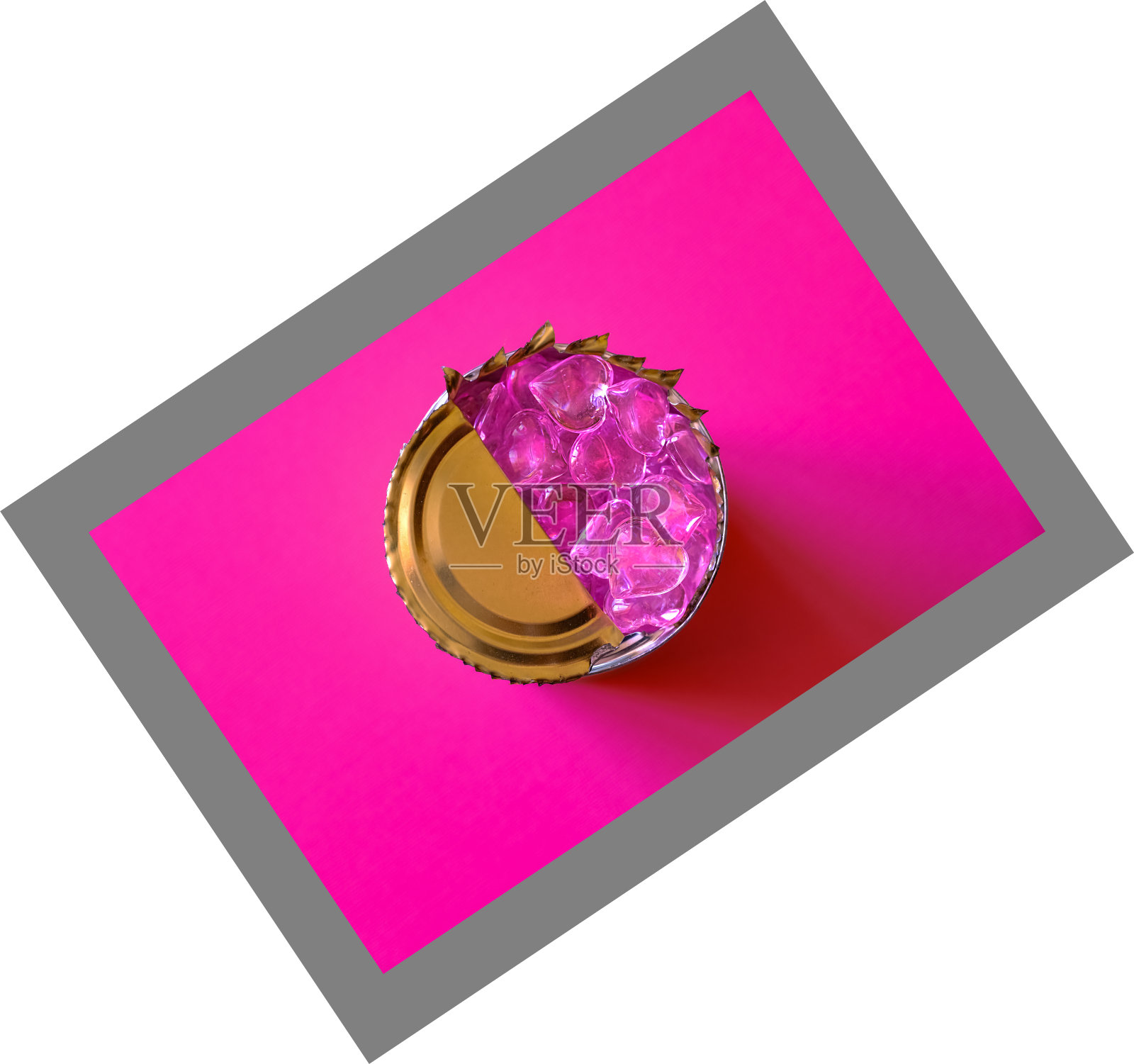 粉红色的心在一个锡罐在紫红色的背景。概念:封闭的感觉。假的感情。破碎的心照片摄影图片