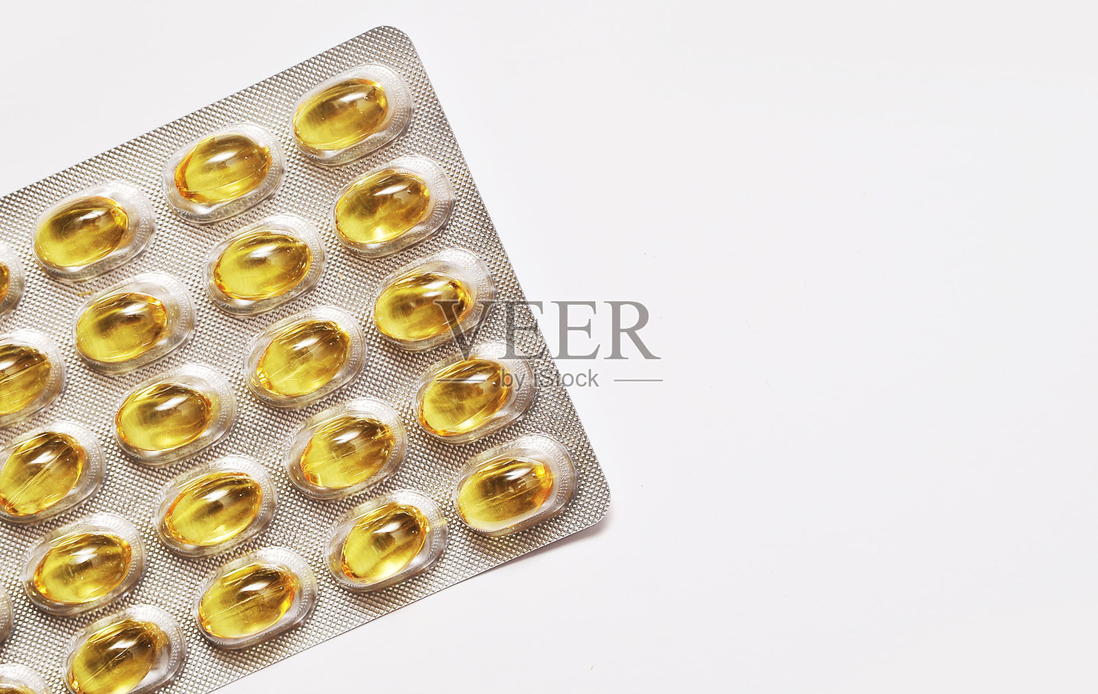 光背景下胶囊中的鱼脂肪。照片摄影图片