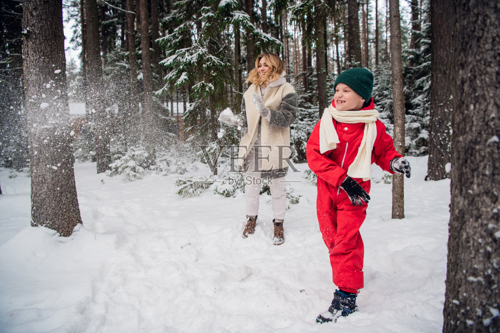 在一个凉爽的冬天的早晨,有趣的家庭户外游戏,妈妈和儿子在树林里玩照片摄影图片