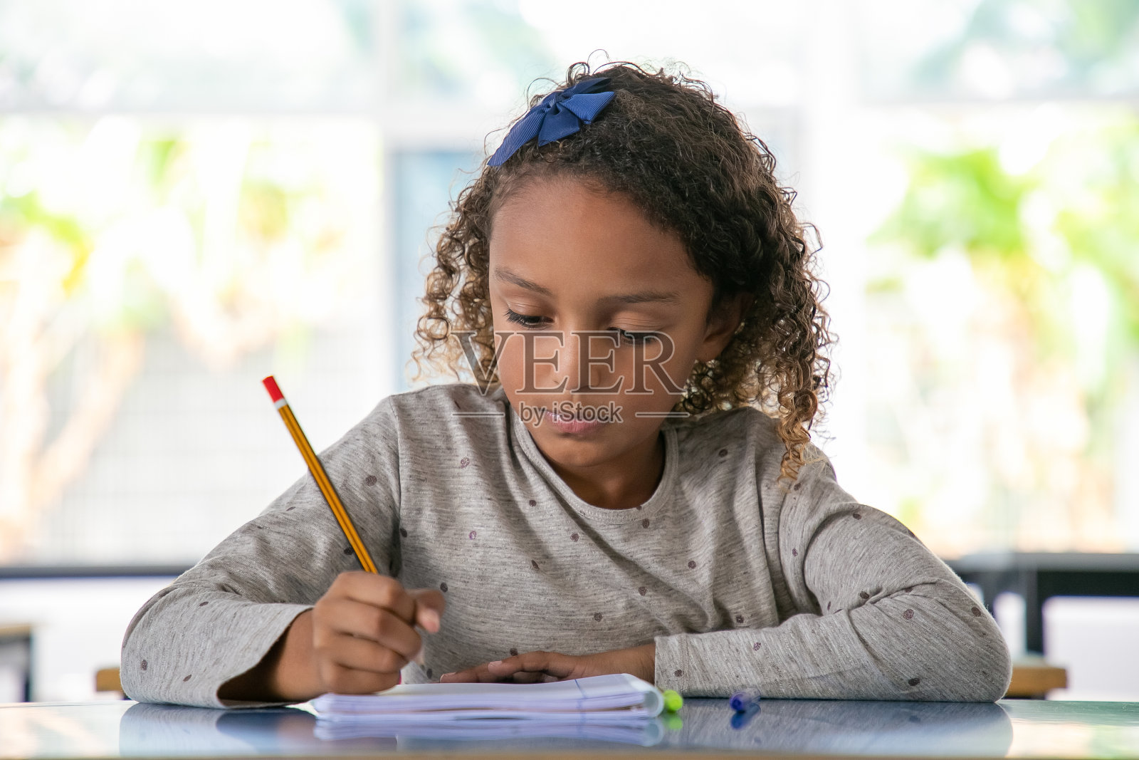 专注的非裔美国女孩坐在课桌前照片摄影图片