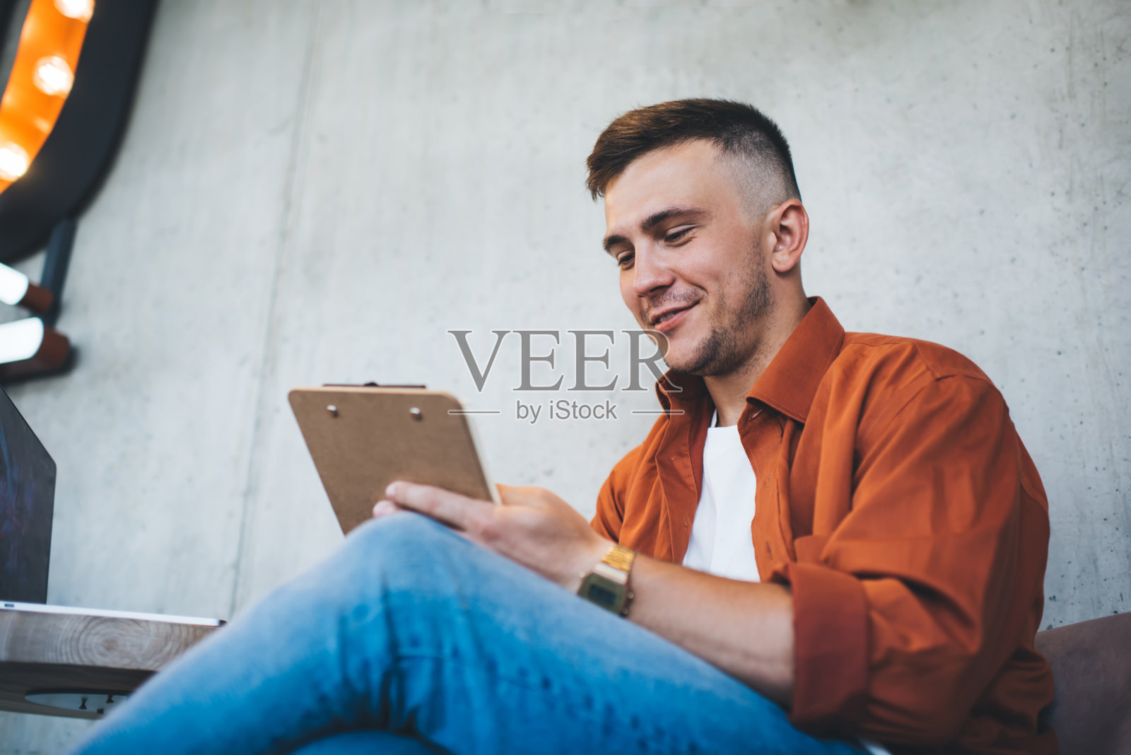 微笑的男人在写字板上做笔记照片摄影图片