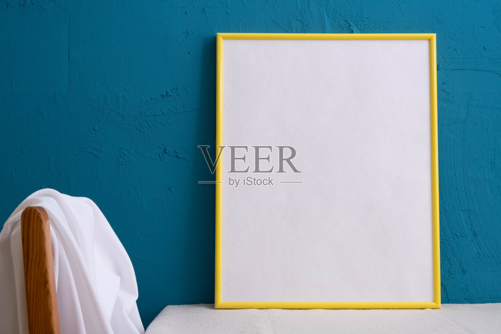 桌子上有一个蓝色背景的黄色大画框照片摄影图片