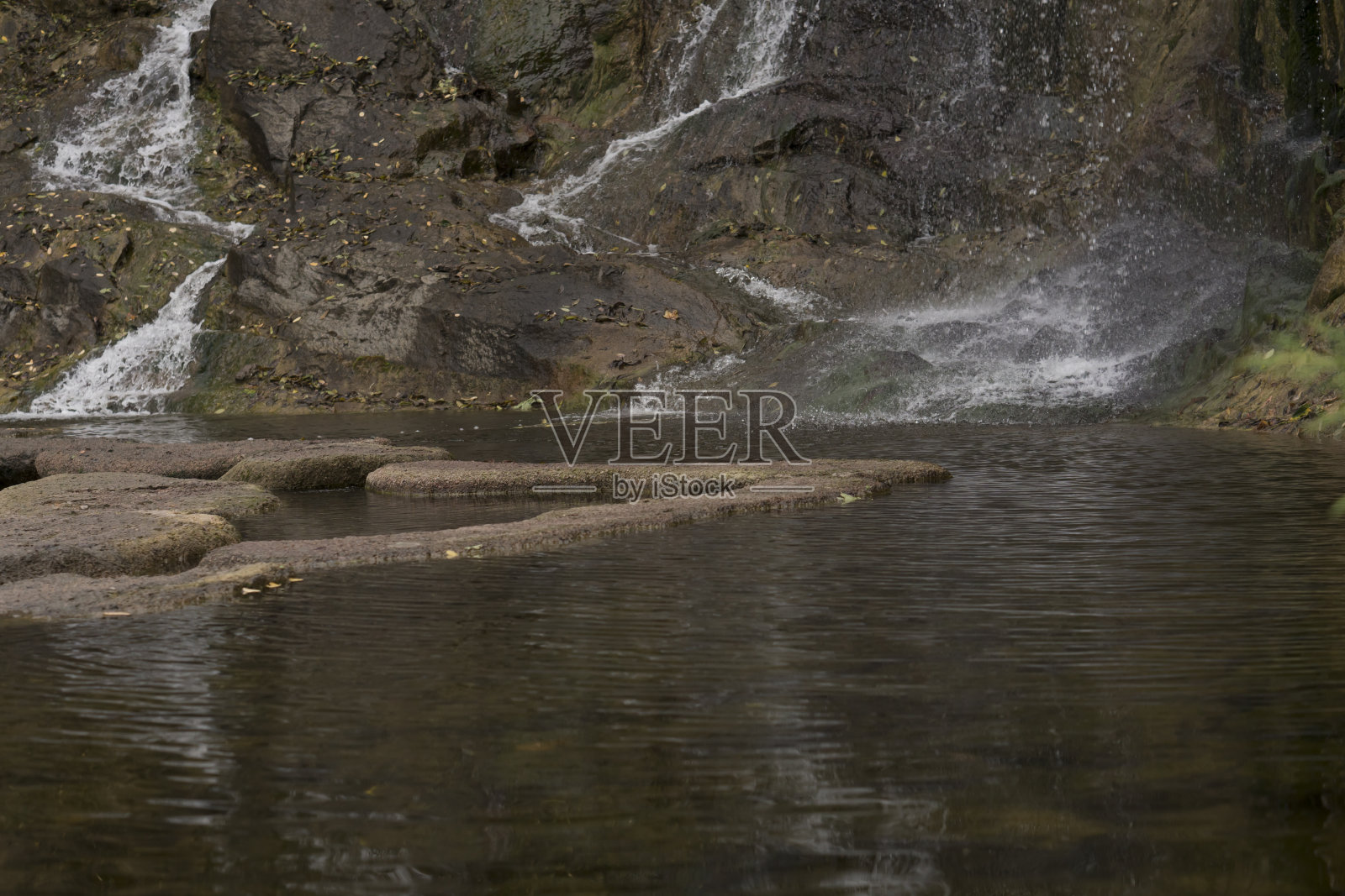 瀑布,水从岩石流到湖里照片摄影图片