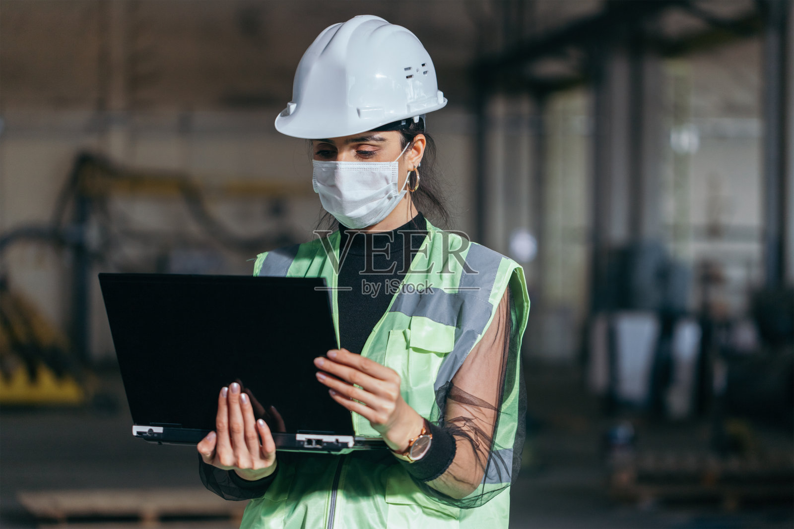 女工程师在工厂工作时使用笔记本电脑照片摄影图片