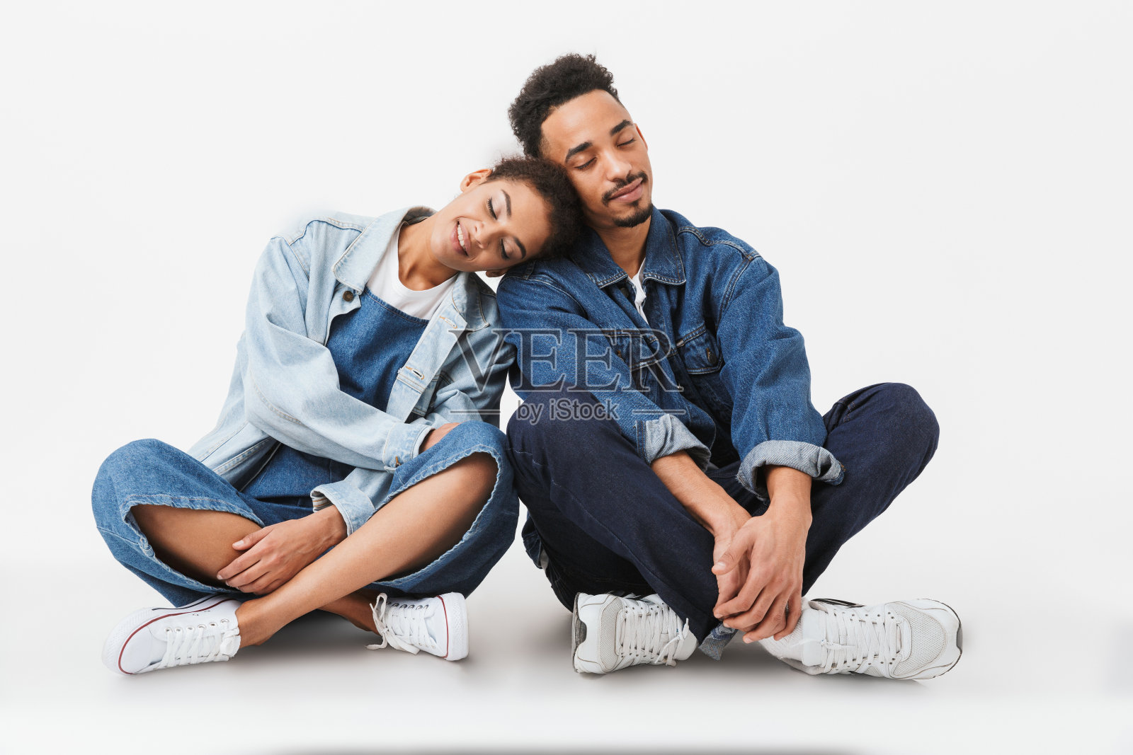 一对穿着牛仔衬衫的非洲夫妇坐在地板上照片摄影图片