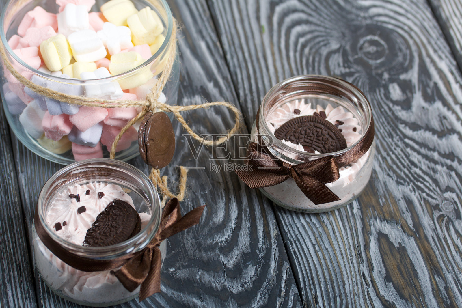 罐子里的棉花糖。还有饼干和巧克力。松木板。照片摄影图片